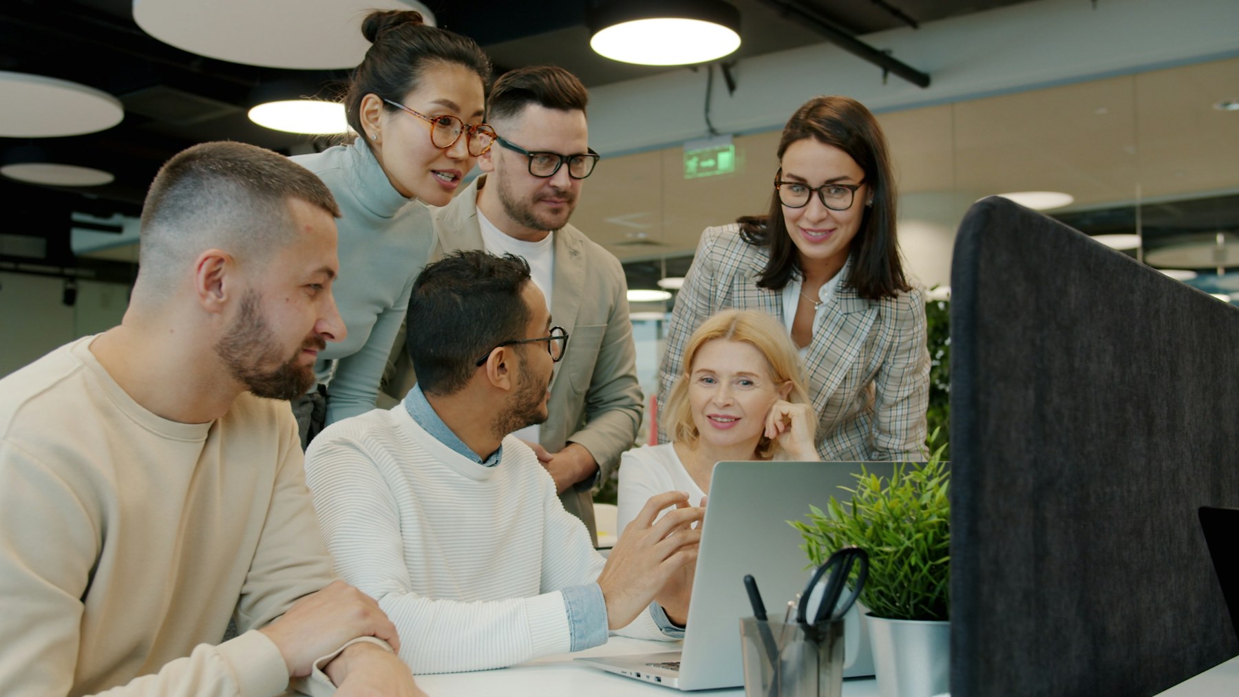 A diverse workplace team collaborating around a laptop